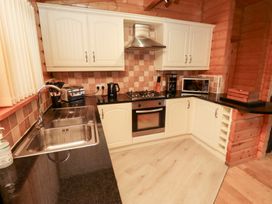 A kitchen with appliances and cabinets at Heather Cottages - Grey Heron in Bamburgh