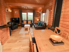 A living room with seating and a dining area at Heather Cottages - Grey Heron in Bamburgh