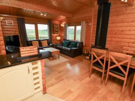 A living room with a sofa and a dining table at Heather Cottages - Grey Heron in Bamburgh