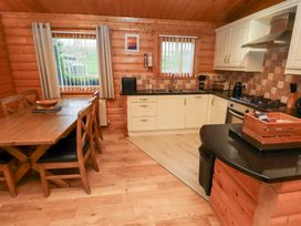 A kitchen with a dining table and appliances at Heather Cottages - Grey Heron in Bamburgh