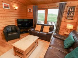 A living room with sofa and television at Heather Cottages - Grey Heron Bamburgh