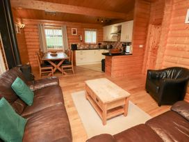 A living room with a dining table and kitchen counter at Heather Cottages - Grey Heron in Bamburgh