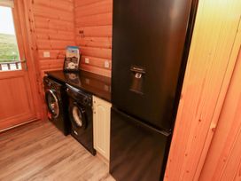 A laundry room with a washing machine, dryer, and refrigerator at Heather Cottages - Grey Heron in Bamburgh