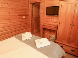 A bedroom with a bed and television at Heather Cottages - Grey Heron in Bamburgh