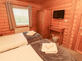 A bedroom with two beds and a TV at Heather Cottages - Grey Heron in Bamburgh