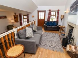 A living room with a sofa and fireplace at Heather Cottages - Grey Seal in Bamburgh