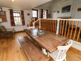A dining room with a wooden table and benches at Heather Cottages - Grey Seal in Bamburgh