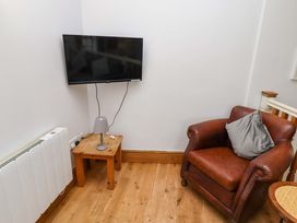 A living room with a television and armchair at Heather Cottages - Grey Seal in Bamburgh