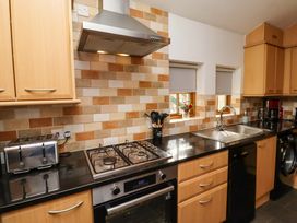 A kitchen with cabinets, sink, hob, and appliances at Heather Cottages - Grey Seal, Bamburgh