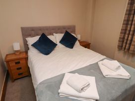 A bedroom with a double bed and bedside tables at Heather Cottages - Grey Seal Bamburgh