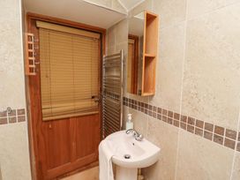 A bathroom with a sink, mirror and towel rail at Heather Cottages - Grey Seal, Bamburgh