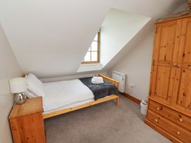 A bedroom with a single bed and wardrobe at Heather Cottages - Grey Seal in Bamburgh