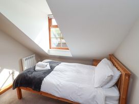 A bedroom with a bed and window at Heather Cottages - Grey Seal in Bamburgh