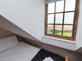 A bedroom with a window view at Heather Cottages - Grey Seal Bamburgh