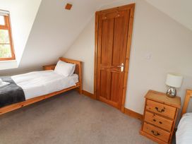A bedroom with a single bed and a nightstand at Heather Cottages - Grey Seal in Bamburgh