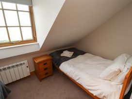 A bedroom with a bed and nightstand at Heather Cottages - Grey Seal, Bamburgh