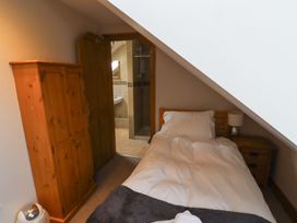 A bedroom with a single bed and wardrobe at Heather Cottages - Grey Seal in Bamburgh