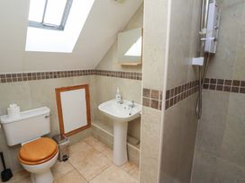 A bathroom with a toilet, sink, and shower at Heather Cottages - Grey Seal, Bamburgh