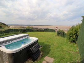 An outdoor space with a hot tub and sea view at Heather Cottages - Grey Seal in Bamburgh