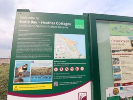 An information board about Budle Bay Heather Cottages in Lindisfarne National Nature Reserve