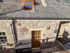 A stone exterior with a door and window at Heather Cottages - Plover in Bamburgh