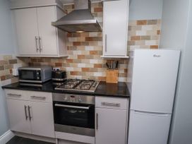 A kitchen with various appliances at Heather Cottages - Plover in Bamburgh