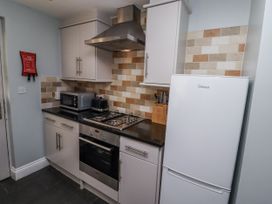 A kitchen with a stove and refrigerator at Heather Cottages - Plover in Bamburgh
