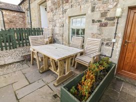 An outdoor seating area with a table and chairs at Heather Cottages - Plover in Bamburgh