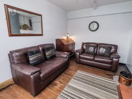 A living room with brown sofas and a mirror at Kittiwake Cottage, Budle Bay