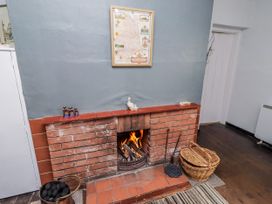 A living room with a fireplace and a map at Kittiwake Cottage, Budle Bay