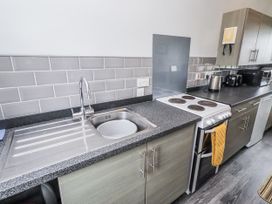 A kitchen with a sink and stove at Kittiwake Cottage, Budle Bay