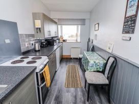 A kitchen with appliances and a table at Kittiwake Cottage, Budle Bay