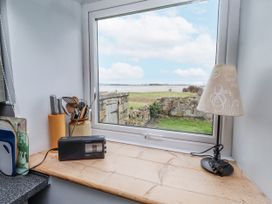 A kitchen countertop with a window view at Kittiwake Cottage, Budle Bay Bamburgh