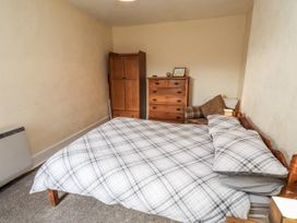 A bedroom with a bed and furniture at Kittiwake Cottage, Budle Bay