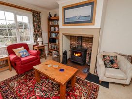 A living room with a stove and bookshelf at St Marys Cottages No4 Low Newton-by-the-Sea