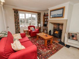 A living room with a sofa, armchair, coffee table and fireplace at St Marys Cottages No4 in Low Newton-by-the-Sea