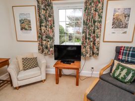 A living room with a television and seating at St Marys Cottages No4 Low Newton-by-the-Sea