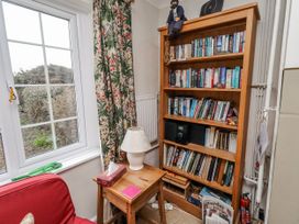 A living room with a bookshelf and lamp at St Marys Cottages No4 Low Newton-by-the-Sea