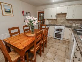 A kitchen with a wooden dining table and chairs at St Marys Cottages No4 Low Newton-by-the-Sea
