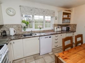 A kitchen with sink, countertop, and dining table at St Marys Cottages No4 Low Newton-by-the-Sea
