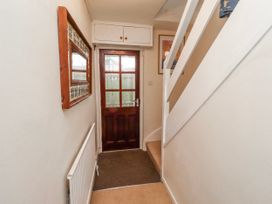 A hallway with a door and a staircase at St Marys Cottages No4 Low Newton-by-the-Sea