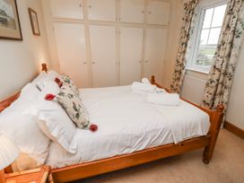 A bedroom with a bed and wardrobe at St Marys Cottages No4 Low Newton-by-the-Sea