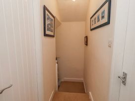 A hallway with a staircase and framed pictures at St Marys Cottages No4 Low Newton-by-the-Sea