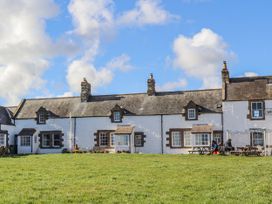A building with windows and people sitting at a table at St Marys Cottages No4 in Low Newton-by-the-Sea