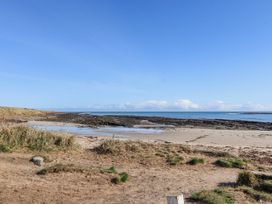 A beach area with rocks and ocean at St Marys Cottages No4 Low Newton-by-the-Sea