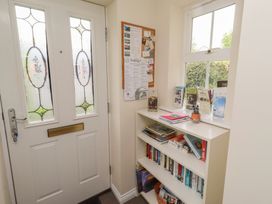 A hallway with a door and bookshelf at Sugar Sands in Longhoughton