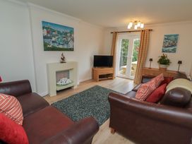 A living room with a television and a rug at Sugar Sands in Longhoughton