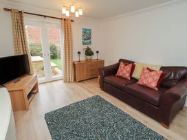 A living room with a sofa and television at Sugar Sands in Longhoughton