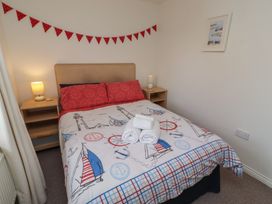 A bedroom featuring a bed with a nautical themed blanket at Sugar Sands in Longhoughton