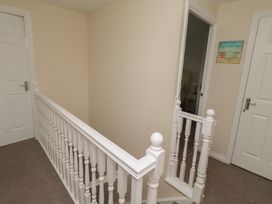 A hallway with stairs and doors at Sugar Sands Longhoughton